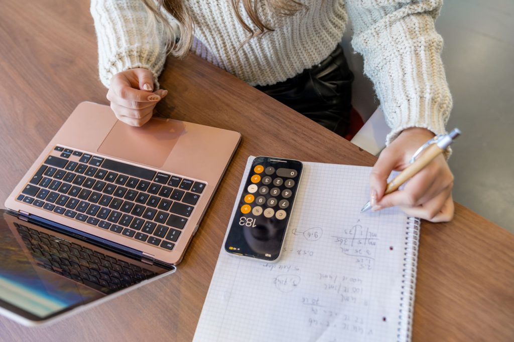 student met een witte trui en een roze laptop maakt huiswerk opdrachten voor de RWT toets. Ze oefent regelmatig met RWT oefenopdrachten voor de PABO