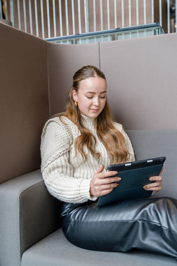 Vrouwelijke student met een witte trui is op haar Ipad een oefentoets aan het maken voor de RWT toets voor de Pabo. Dit doet ze met les materiaal van rekenexpertonline.nl